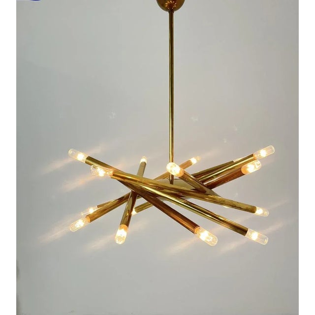 A rare Stilnovo chandelier made in the 1960s, featuring a sculptural structure in polished brass. The minimalist yet...