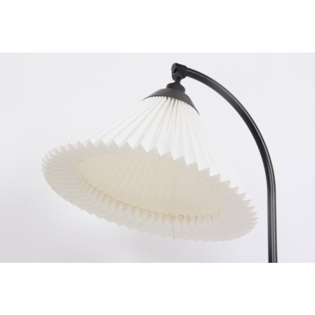 The Le Klint floor lamp, made of black lacquered steel with a hand-pleated lampshade, bears the model number 386 and was...