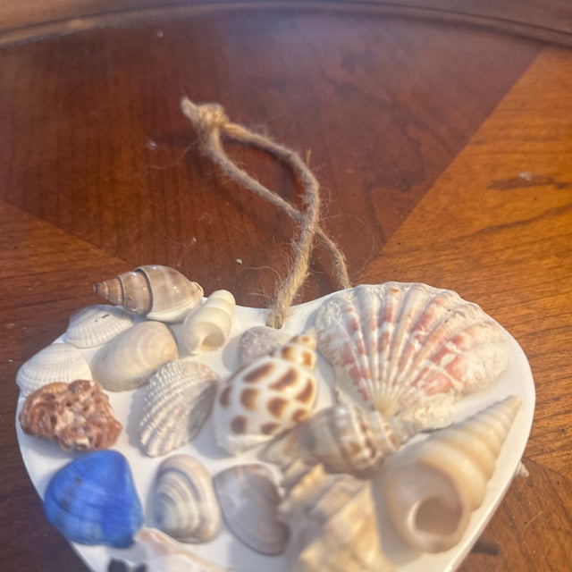 Bring the serene beauty of the ocean directly to your home with this beautiful, handmade seashell heart door hanger.This...
