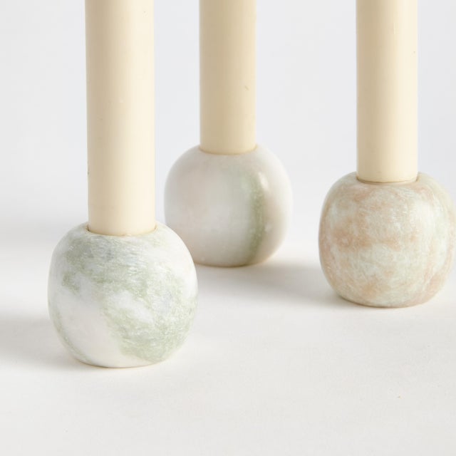 Rounded in form and made to hold standard tapers, these marble candleholders with naturally occurring green and pink...