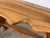 This bench is crafted from a solid slab of walnut with a live, freeform edge running along both long sides. The top rests...