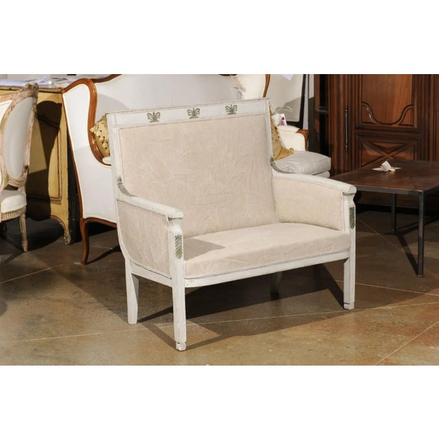 A French Empire style painted wood marquise chair from the 19th century, with carved palmettes. Born in France during the...