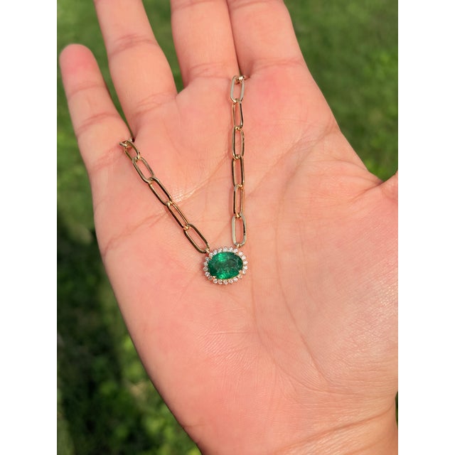 This pendant necklace features a 1.99 carat emerald set in 14K yellow gold. The emerald measures approximately 9 x 7 mm...