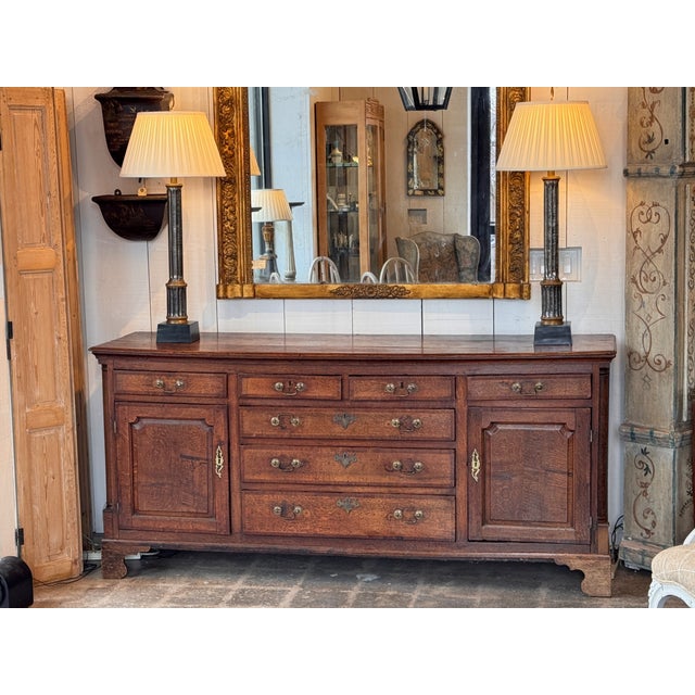 Long oak dresser base with molded top above four short drawers over three long graduated drawers, flanked by two paneled...