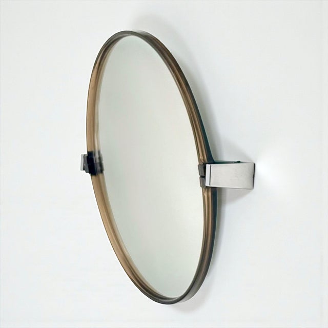 Round pivot wall mirror produced in France during the 1970s, presumably by Allibert. The mirror features a thin smoked...