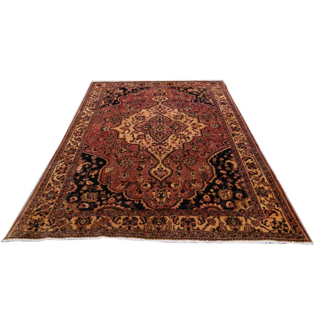 This beautifully hand-knotted woolen rug, with its vibrant multi-colored medallion pattern set against a warm red...