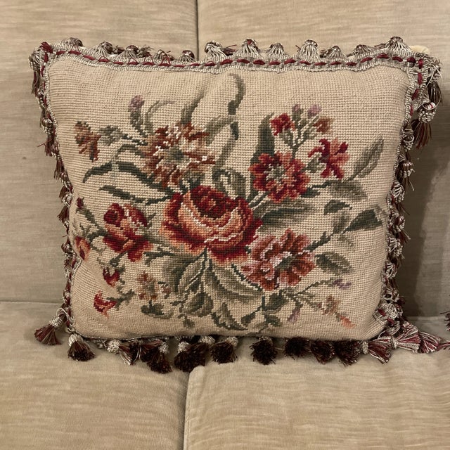 Pair of needlepoint rectangular pillows on gold ground with red roses and other florals, tassel fringe border. Grand...