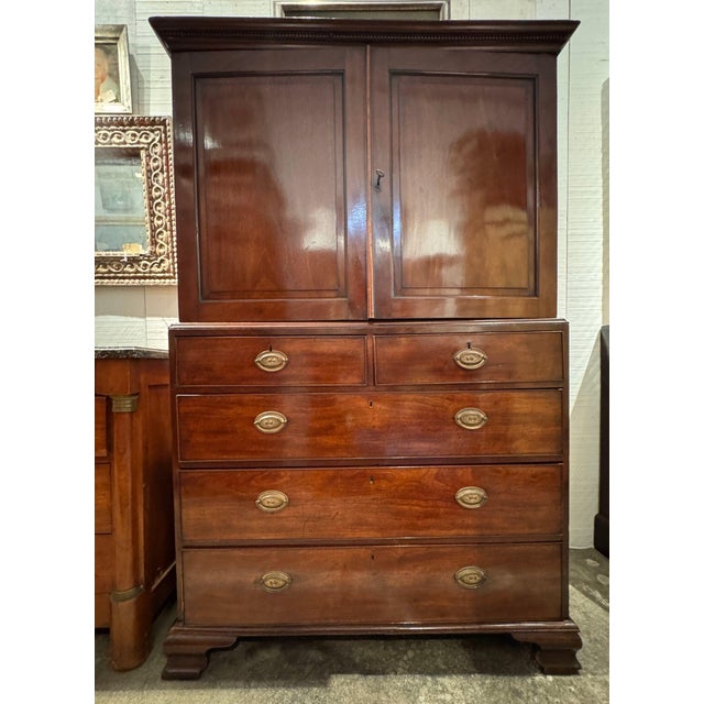 19th century mahogany cabinet with a dentil cornice and two paneled doors opening to an interior fitted with nine small...