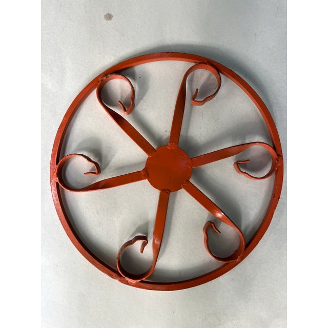 Single round metal wheel with curved flat metal spokes and orange painted finish.