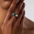 This exceptional Mid Century three-stone ring is centered by a square cut Colombian emerald weighing approximately 2.00...