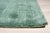 A hand-knotted wool rug, made in India and measuring 4' x 6'. Open green ground with restrained geometric detail — a quiet...