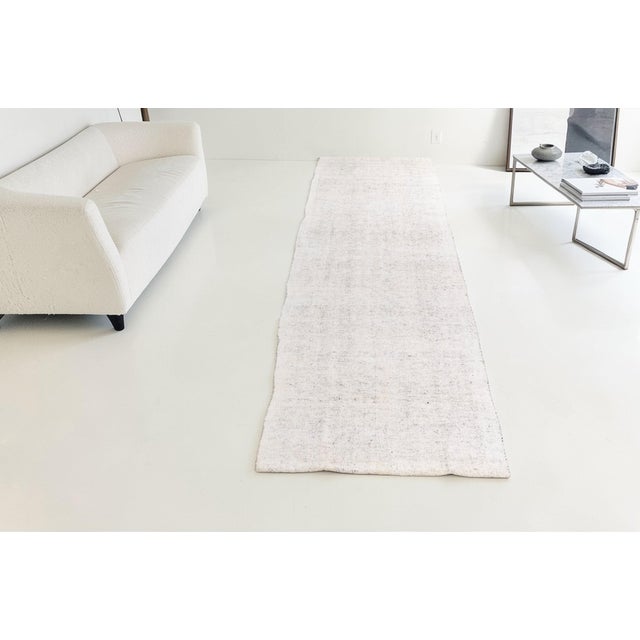 This is a vintage Turkish Oushak rug from the Mid 20th Century. The piece was hand-knotted.