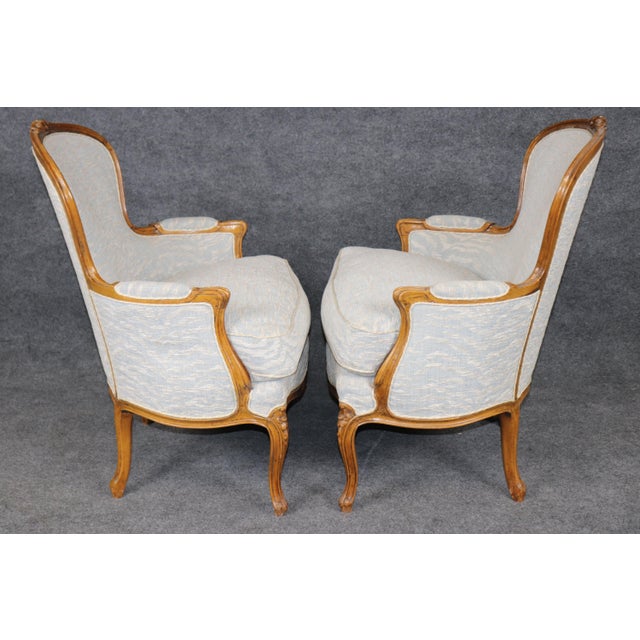 A wonderfully elegant and inviting pair of Louis XV-style balloon-back bergère armchairs, dating to approximately the...