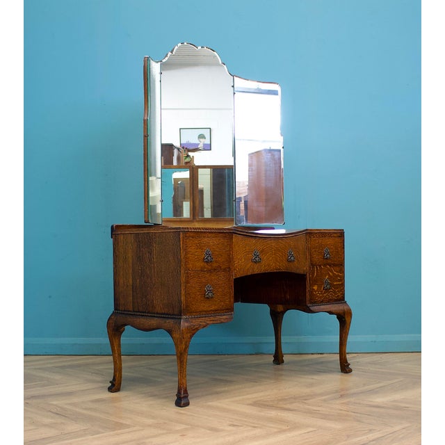 A striking tiger oak dressing table dating from the 1930s, featuring a shaped triple mirror, serpentine front and elegant...