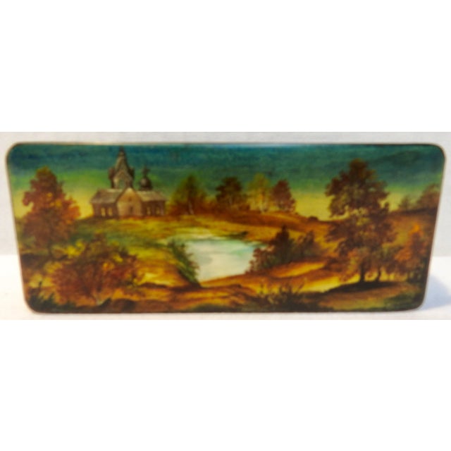 We are offering a small Russian black lacquer box that has been hand painted. The mother-of-pearl river scene is...