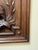Hand-carved solid wood wall panel depicting a bird motif framed by an architectural border. The carving shows expressive...