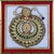 A striking Indian decorative plaque featuring an elaborate jewel-like circular ornament, finely arranged with green, red...