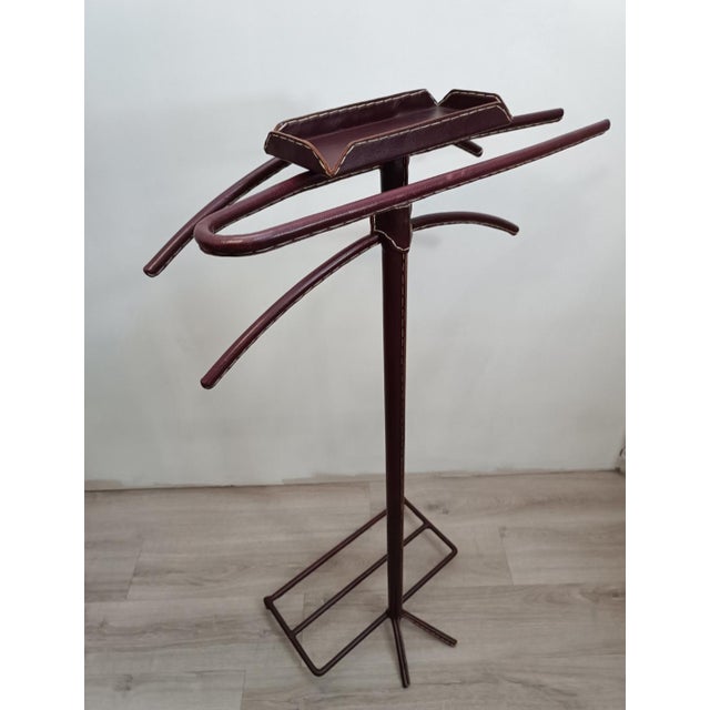 Iconic, chic, and luxurious valet stand by Jacques Adnet. France, 1950s. Tubular metal frame, entirely covered in saddle-...