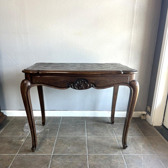 This vintage French oak side table features a beautiful parquet top, cabriole legs, and hand-carved floral details. Its...