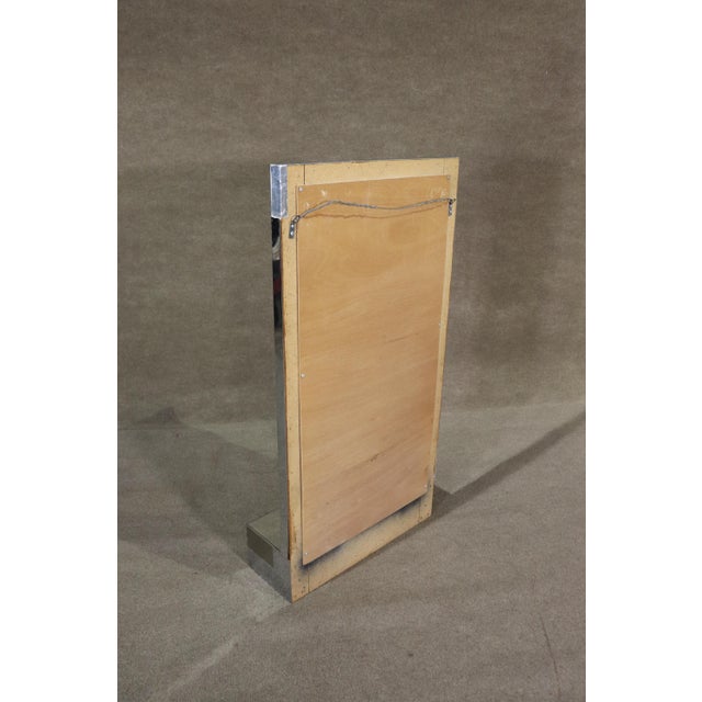 Mid-century modern chrome plated wall mirror with shelf. Great vintage design that holds up in today's modern homes. Made...