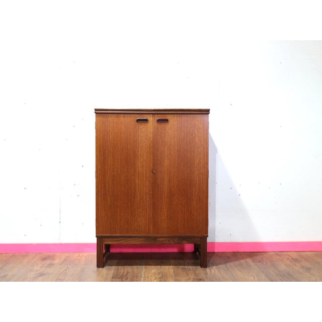 Discover the elegance of the Mid Century Modern Vintage Teak Bar Cabinet by Turnidge of London at Mid Century Traders....