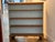 A country pine open bookcase with three fixed shelves above a shaped, scalloped apron resting on bracket feet. The honey-...