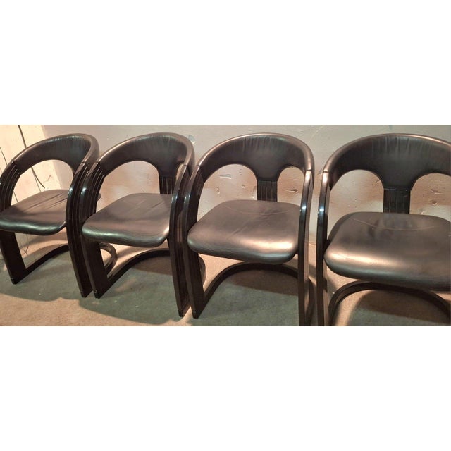 Set of four Springer Onassis dining chairs in black leather and lacquered wood, Designed in the 1980s for Jimeco, these...
