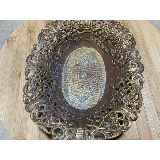 An ornate mid-to-late 20th-century Italian brass oval centerpiece bowl designed in the Hollywood Regency / Baroque Revival...