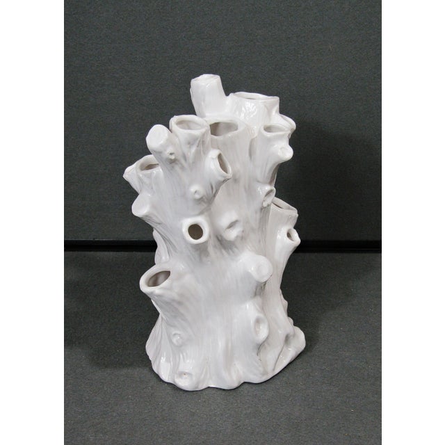 A sculptural white ceramic tree trunk vase featuring 18 openings for individual stems or floral arranging. The faux bois...