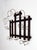 This antique turn-of-the-century wall hat and coat rack pairs a dark-stained wood frame with sculptural bent-wire hooks,...