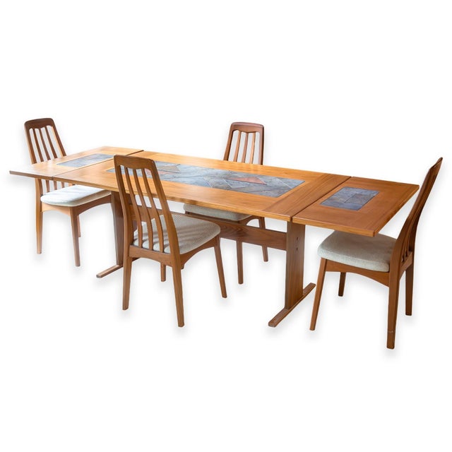 A set of four Benny Linden chairs. Crafted in solid teak and known for their ergonomic, gently curved high backs....