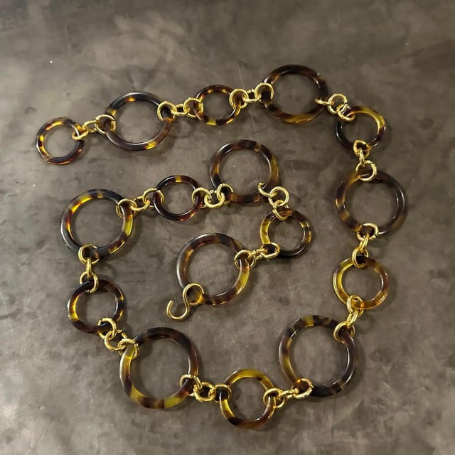 This is a statement fashion belt from the 1980s, showcasing a bold and glamorous aesthetic. It features a series of...