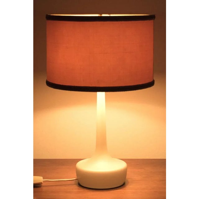 An elegant table lamp from the 1960s with a glass base and brass details. The lamp is in good vintage condition....