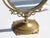 Vintage brass oval shaped vanity mirror. The mirror can be turned due to its mechanism and has a beautiful ornate frame....
