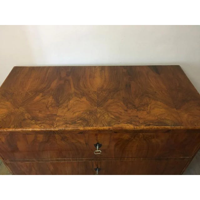 BiedermeIer commode made of walnut veneer made with e-denied coats of arms and exhibited, for the Biedermeier typical,...