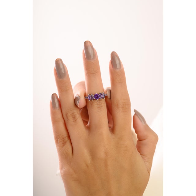 Make a statement with this contemporary Five-Stone Amethyst Ring in 925 Sterling Silver. Featuring a round center stone...