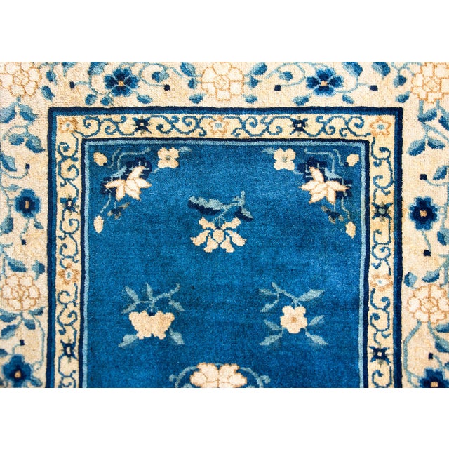 A wonderful early 20th century Chinese Peking rug with a central peony medallion living amidst a field of more peonies,...