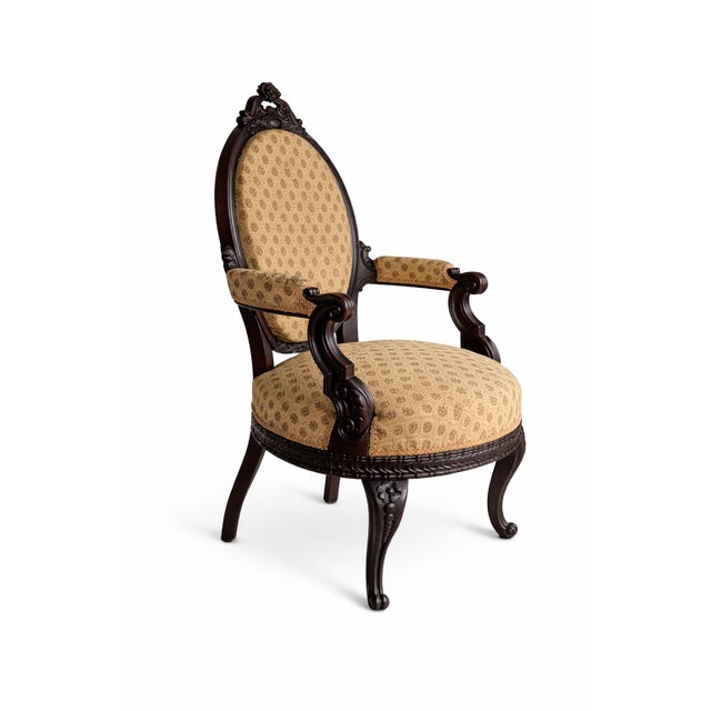 A handsome 19th century Victorian carved walnut armchair featuring a beautifully shaped oval back, richly carved crest,...