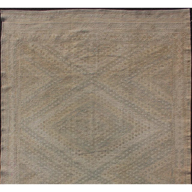 Embroidered vintage Kilim rug from Turkey in shades of tan, light blue and light yellow with geometric pattern. Keivan...