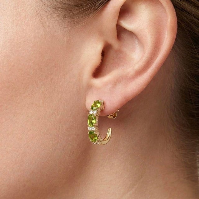 Elevate your jewelry collection with these refined oval-cut peridot and diamond linear drop earrings. Crafted in lustrous...
