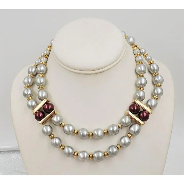 This is part of Chairish’s Costume Jewelry assortment. Goldtone grey faux-baroque pearls with red beads two strand festoon...