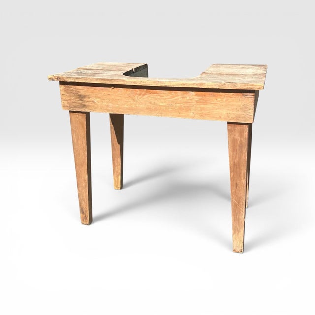 This item is an primitive wooden work table, likely from the late 19th or early 20th century. The unique cutout and...