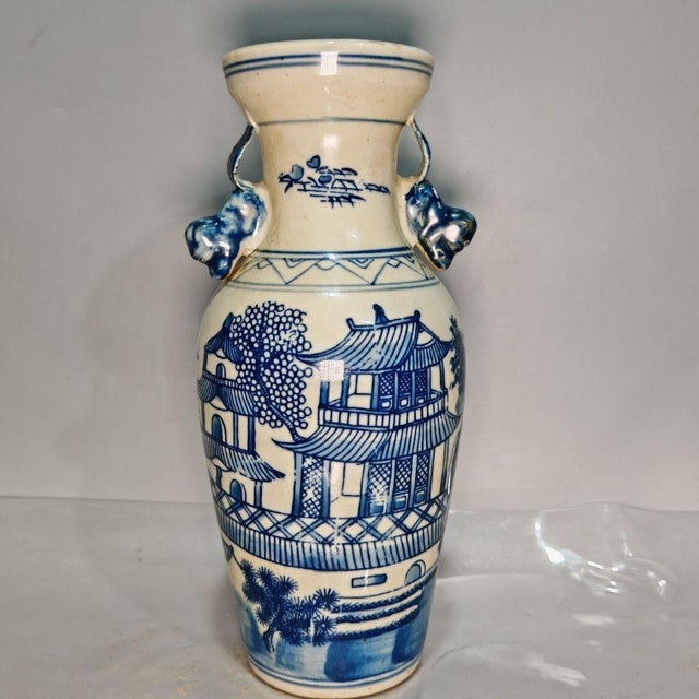 This matching pair of blue and white porcelain vases features sculpted decorative side handles. Each vase is hand-painted...