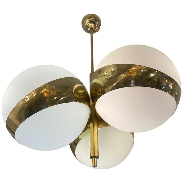 Stilnovo's Nido lamp features three large white globes. Its metal structure consists of three brass rings in a nest shape,...