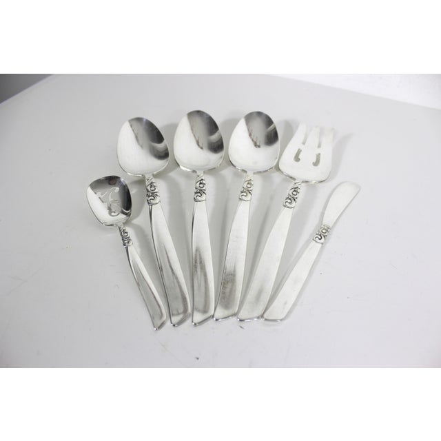 Set of 6 silverplated serving spoons, meat fork, butter knife and slotted bon bon spoon in the 1955 South Seas Community...
