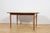 This is a rectangular-shaped teak dining table manufactured by G-Plan in the 1960s. The table has reinforced edges of the...