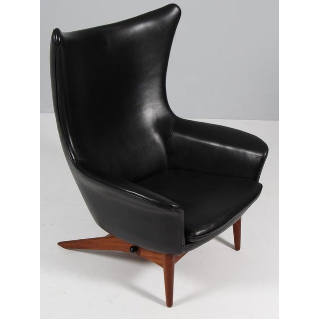 H. W. Klein lounge chair in original black leather Teak base in tilt function. Model 207, made by Bramin This piece is...
