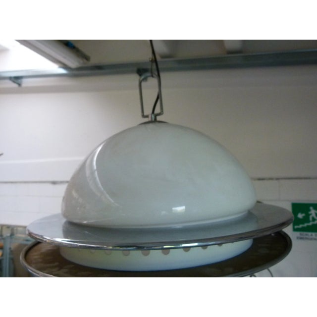 This ceiling lamp is made up of two 1960s glasses with an iron and stainless steel structure. This piece is attributed to...