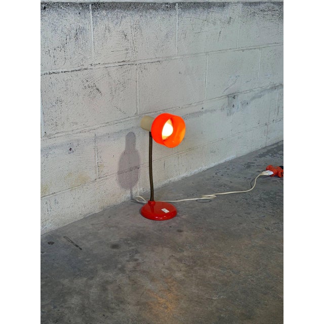 A flexible gooseneck arm gives this table lamp functional directability. The vibrant red cup shade creates a striking...