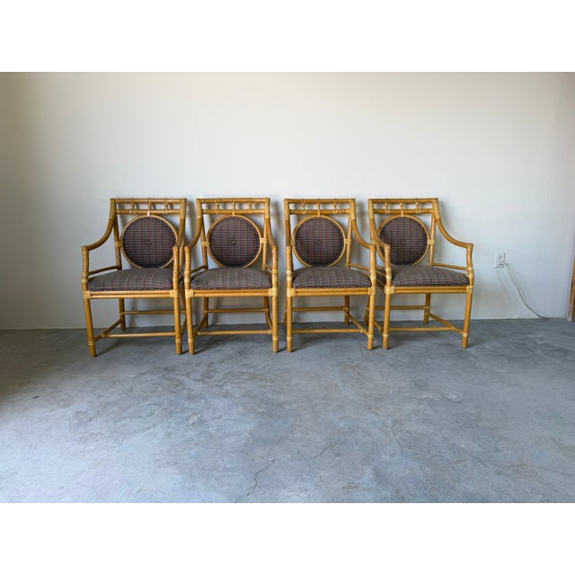 Elegant set of four McGuire-style dining armchairs featuring bamboo frames with signature leather-wrapped joints. Their...